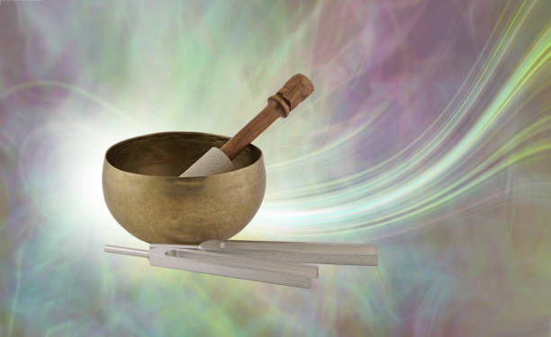 the personal journey of healing Tibetan Singing Bowl with mallet beside tuning forks against a flowing energy background