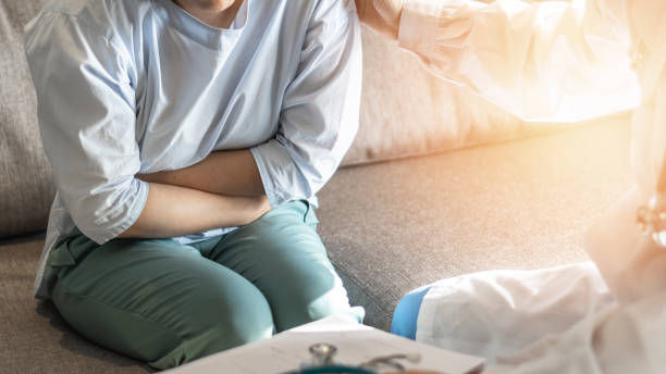 Abdominal pain patient woman having medical exam with doctor on illness.