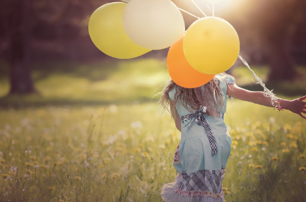 A kid with balloons.