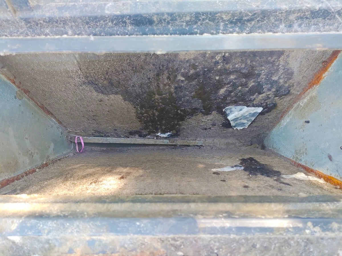 An evaporator coil impacted with debris and dirt.