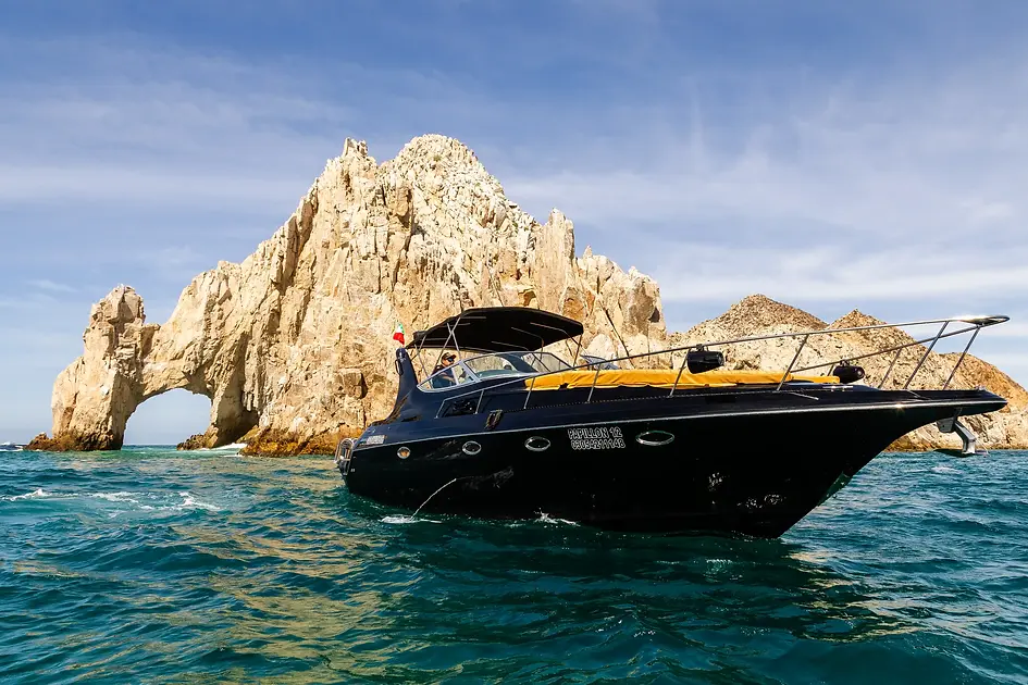 Black yacht Papillon by the arch of cabo.webp