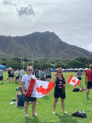 Canadian parents holding a flag while watching their child's rugby game on an Encore Sport Tours trip