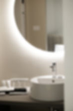 Bagno di design con specchio rotondo retroilluminato e lavabo rotondo