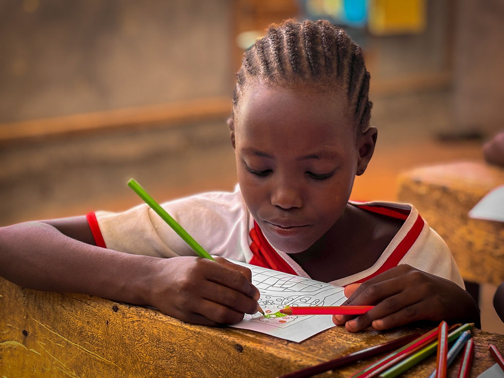 A young girl diligently working on her lessons at a Memusi Foundation school, highlighting the impact of education charity in Kenya.