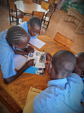 Three students reading a book at a table