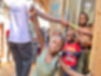 Happy children in Nairobi receiving support from a volunteer during a Memusi Foundation outreach program for street children.