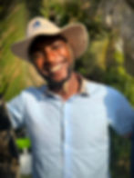 Henry, a former student, now smiling as an adult teacher, illustrating the long-term success of the Memusi Foundation’s child sponsorship program.