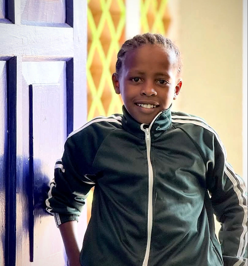 Fatuma, the girl from the adjacent story, smiling in a doorway.