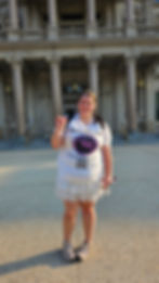 Woman in white skirt and graphic tee in front of columns