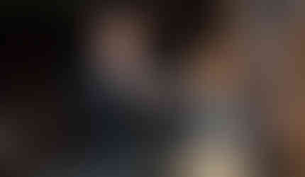 Two event hosts speaking to attendees with a microphone, gesturing while addressing the group in Foundation House's historic interior.