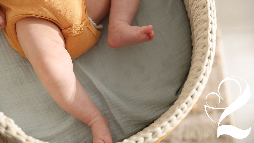 Close-up of a baby resting in a woven bassinet with soft sage green bedding and warm neutral tones, creating a calm and cozy nursery atmosphere.