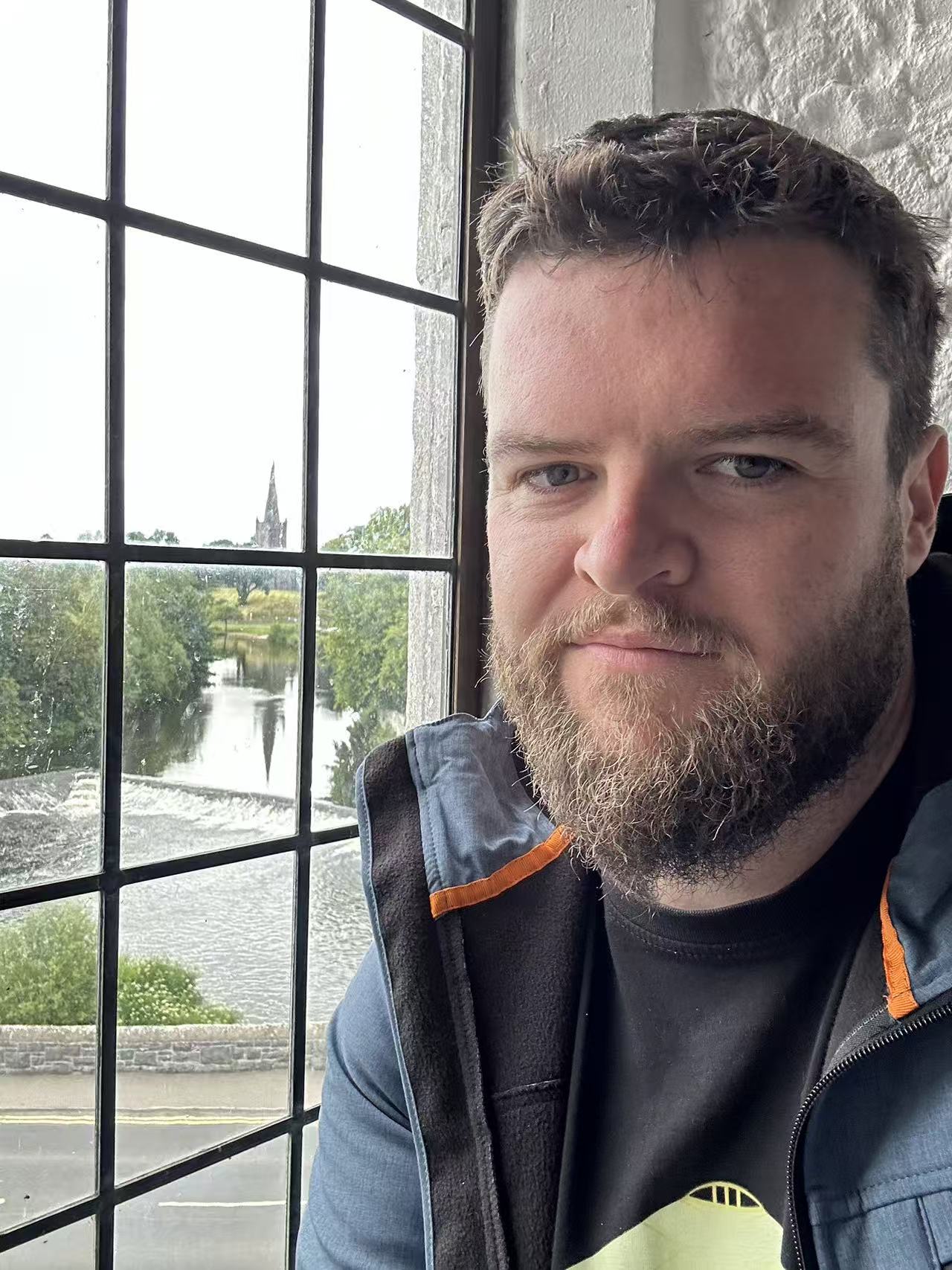English instructor in a professional headshot near a window.