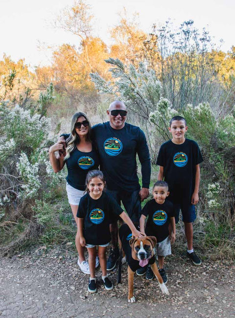 A family and their dogs wearing matching dog and owner shirts