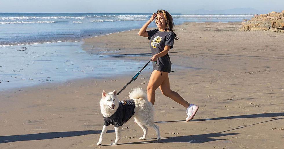 HAppy woman walking her dog on the beach