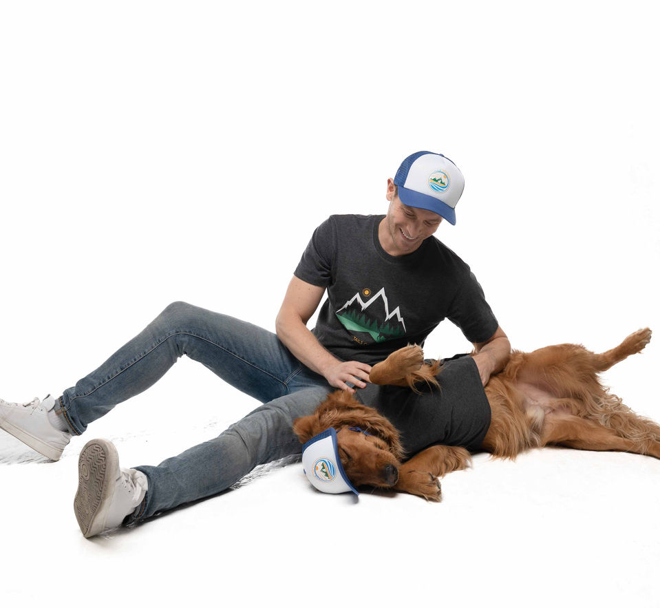 Man and dog wearing matching blue hats