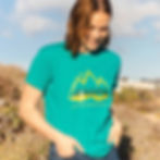 Thumbnail: Woman in nature dressed in an eco-friendly dog mom shirt in teal with a Tails on Trails hiking dog design