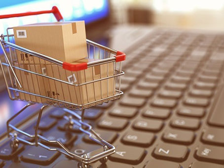 Carrinho de mercado com caixas em cima de um teclado de computador