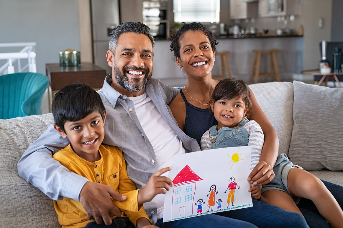 A south asian happy family sitting on couch