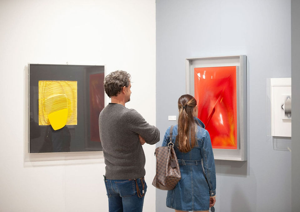 Due visitatori ammirano opere dai colori primari all'interno di Cremona Art Fair, tra pittura contemporanea e percorsi espositivi delle gallerie partecipanti.