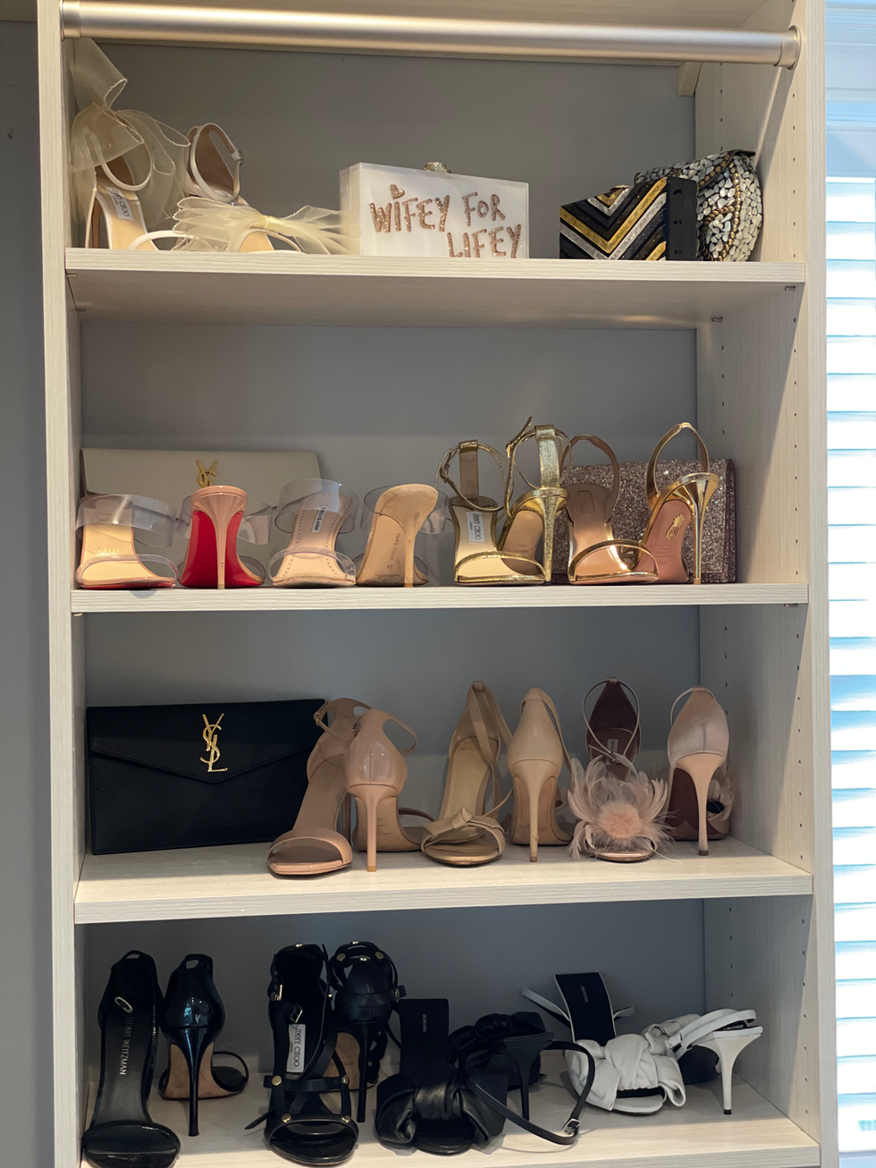 dress shoes organized on walk in closet shelves