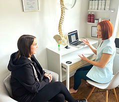 Osteopath explaining treatment plan to patient in clinic
