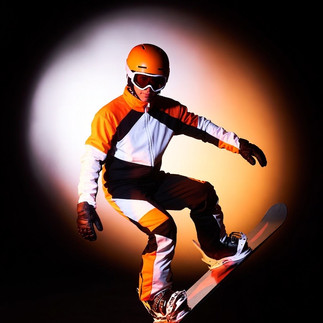 One of them is lying headfirst in the deep snow, the others are laughing and pulling him out.