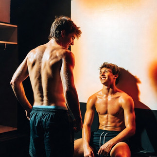 Austin lacht in die Nacht, während das Flutlicht seine definierten Bauchmuskeln betont.