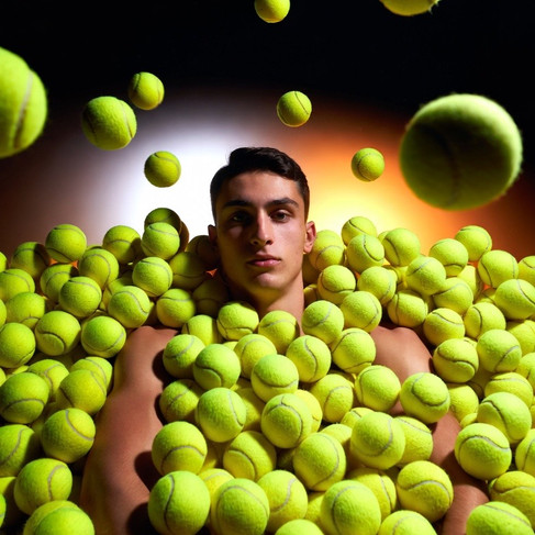 Shirtless tennis player cooling down, water bottle in hand