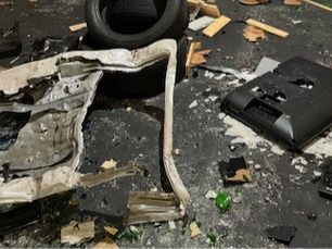 Rage room with broken glass and items on the floor