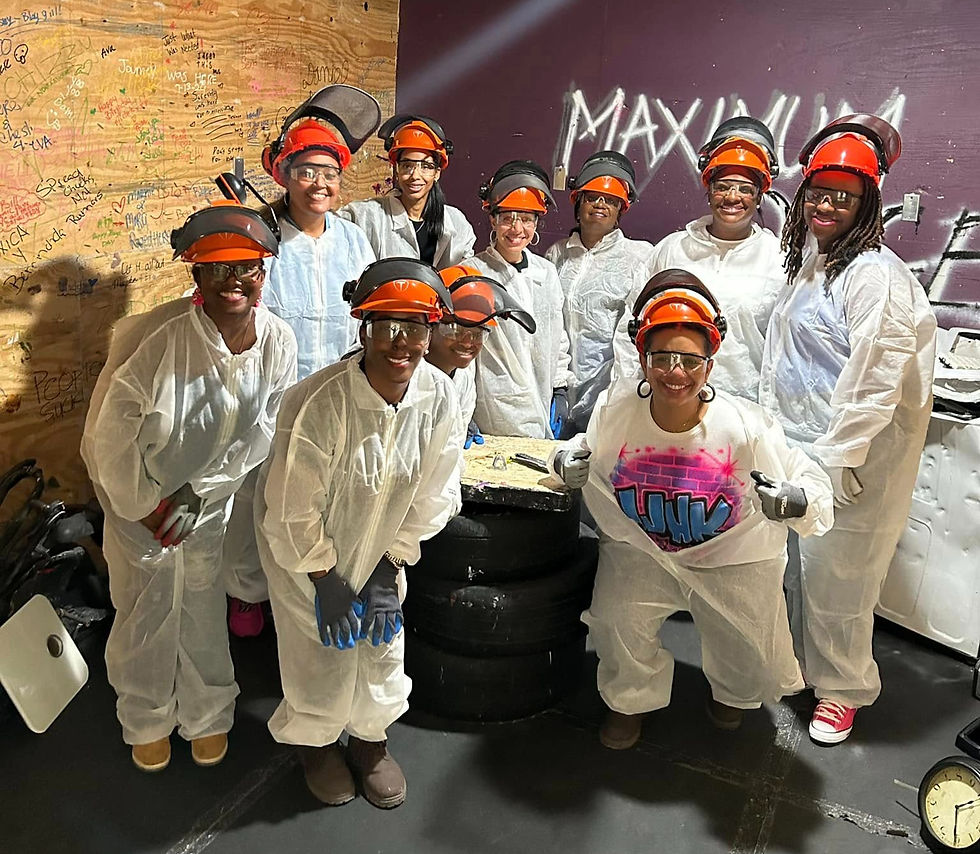 Large group posing together in safety gear after a fun rage room session at Maximum Rage.