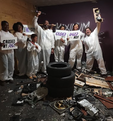 Rage Room Party guests pose for a photo right after a special "Radio" themed party part of Team building and corporate event at Maximum Rage rage room in Humble, TX. Also know as wreck room, break room, smash room, and rage room.