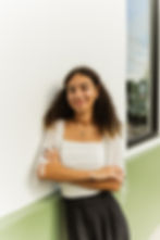 Professional headshot of a smiling web designer with arms crossed, looking confidently at the camera.