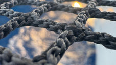 Sonne, die durch das Trampolinnetz von unserem Katamaran Maido durchscheint während unserer Reise zwischen Sardinien und Sizilien