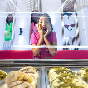 Niña feliz frente a vitrinas de paletas artesanales en Paletados San Patricio.