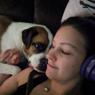 a formerly reactive and aggressive dog enjoying some snuggles with his trainer