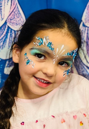 Girl with Face Jewels and Glitter Makeup smiling