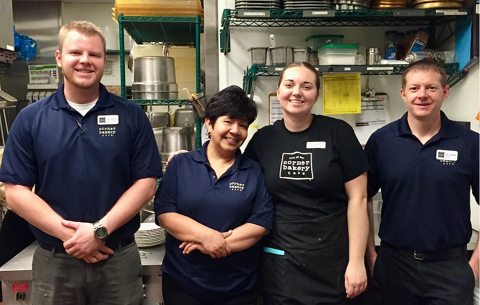 Restaurant managers and team members standing together in a café kitchen, demonstrating restaurant leadership, team culture, and operational excellence.