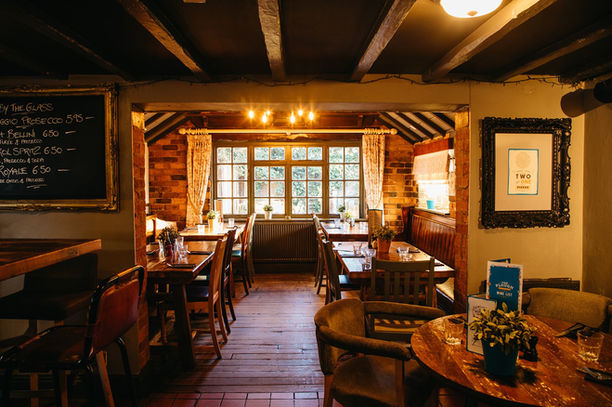 Interior view of a restaurant with tables, menu board, and window.