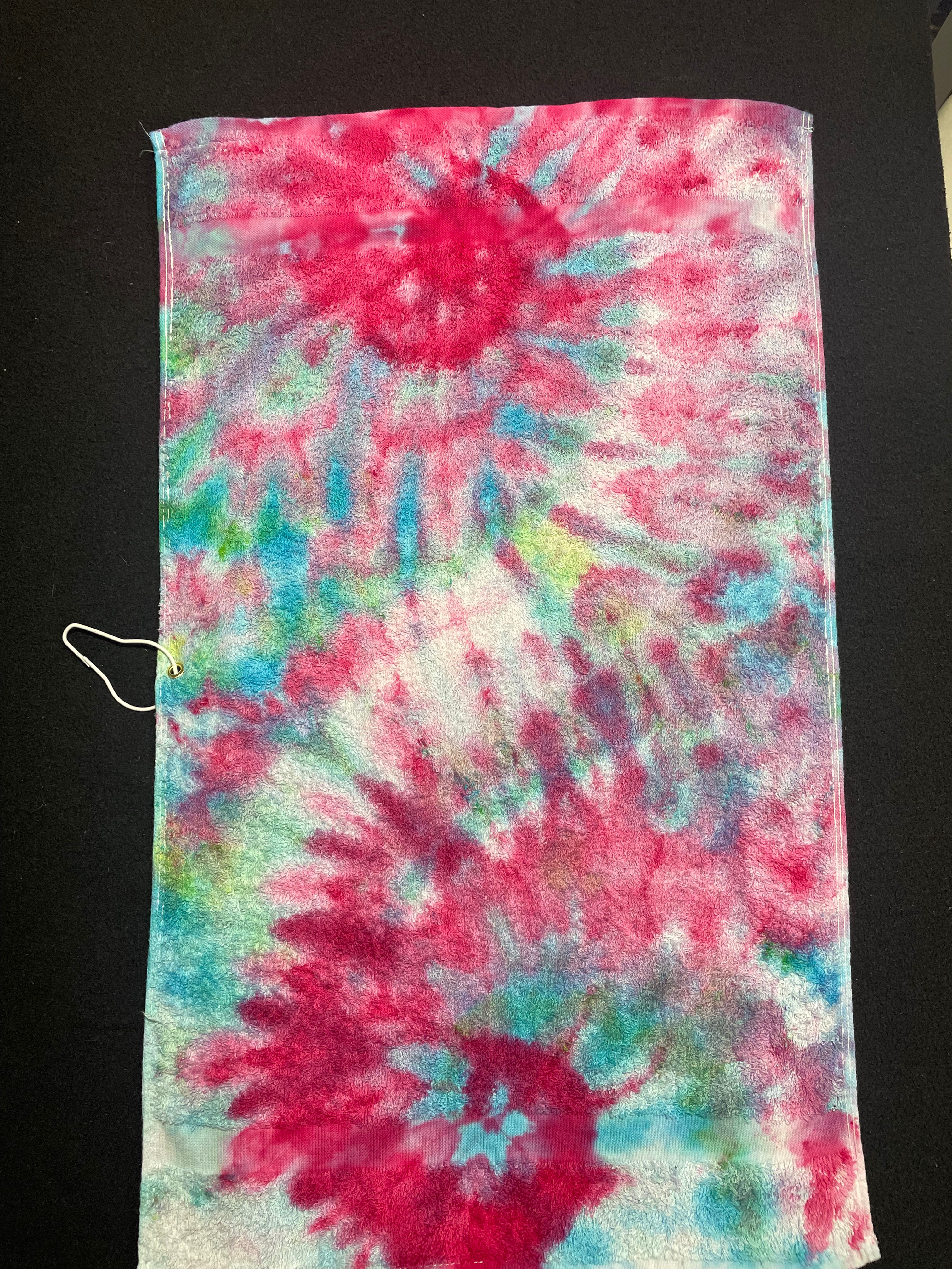 A magneta spiral with teal accents on this tie dyed towel