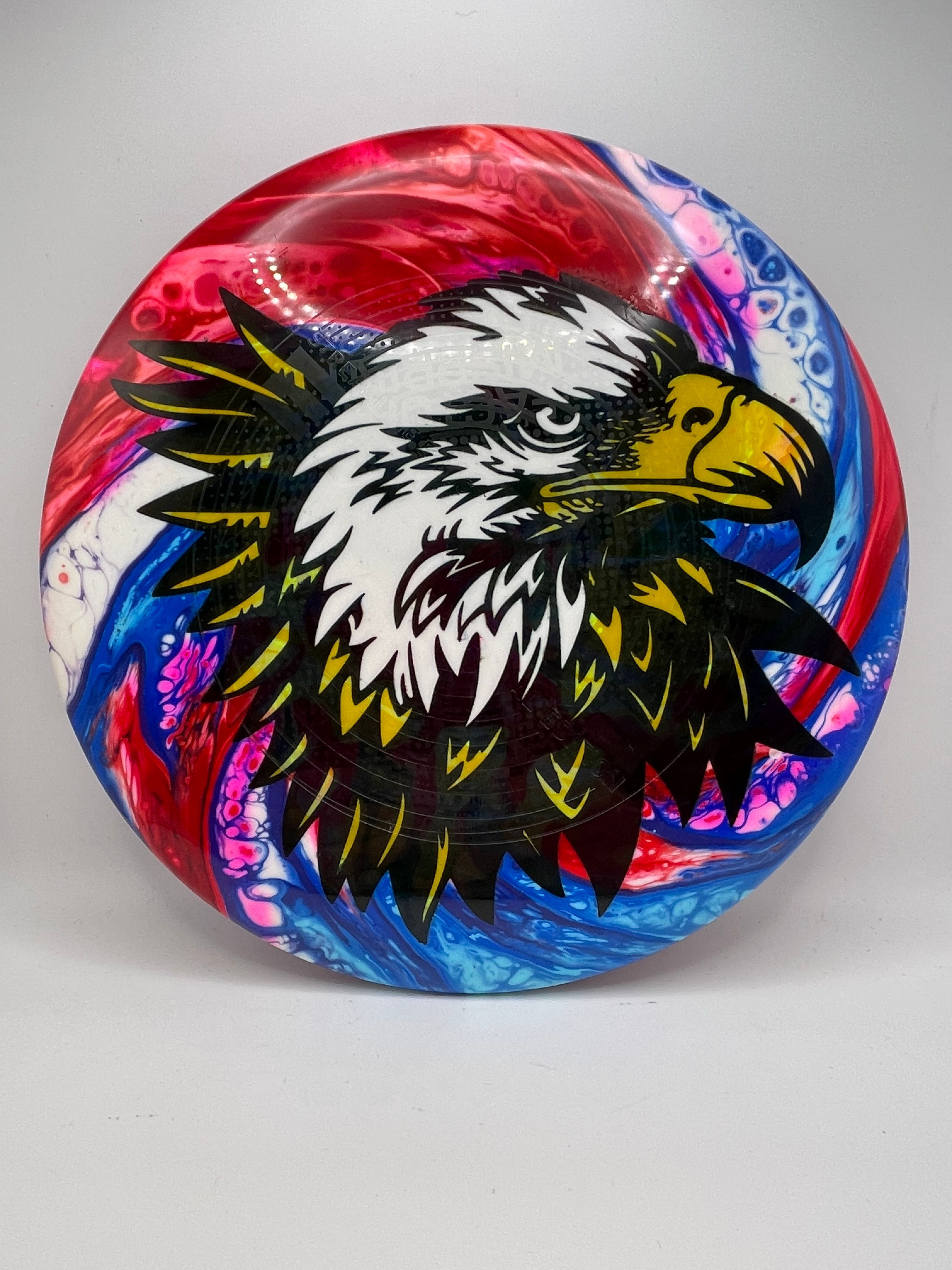 A Bald Eagle with red white and blue in the back ground