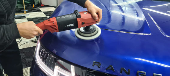 Person poliert ein blaues Auto. FLEX innen Reinigung, Leasing Rückgabe, Politur, smart.