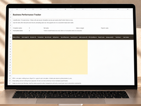 Business Performance Tracker Excel worksheet on a laptop in a warm neutral workspace