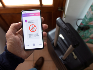 Passageiro frustrado em aeroporto, com mala ao lado, após ter voo cancelado.