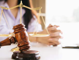 Advogado explicando direitos do consumidor a cliente com contrato e documentos sobre a mesa.