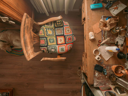 A top view of a work table, chair, and dog