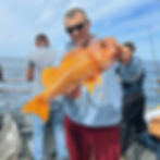 Angler holding a rockfish during Berkeley lingcod fishing.