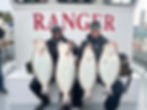 Two men holding large fish on a Berkeley halibut fishing charter.