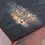 Thumbnail: Close-up foto onderkant rode inlegblok met doorgeschuurd Bausy logo.