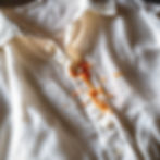 Witte blouse met kaarsvetvlek op de voorkant.
