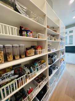 A walk-in pantry that was just set up and organized by a Professional Home Organizer, or Professional Pantry Organizer in Los Angeles. Featuring the Hold Everything Metal Powder Coat Basket from Williams Sonoma. Basket's housing specific food categories. Featuring the IDESIGN Linus Large Deep Drawer Bin Clear from The Container Store. 